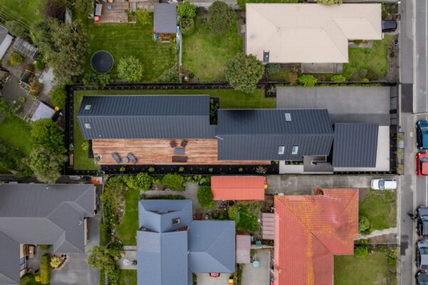 Aerial view of a modern home with timber decking, lawn and structured garden planting