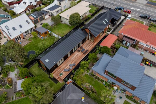 Aerial view of a modern residential property with timber deck, lawn and boundary planting