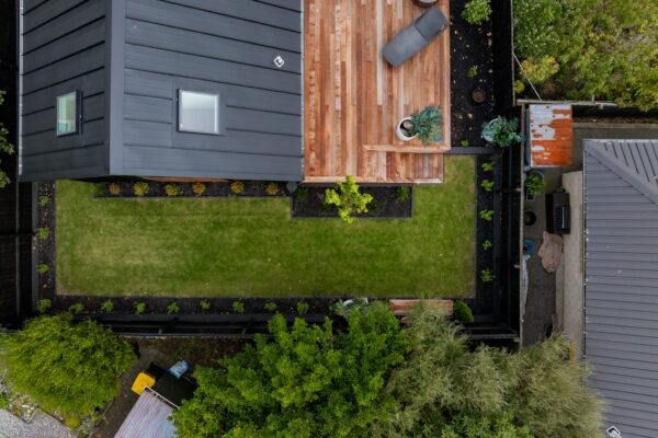 Overhead view of a modern backyard with lawn, timber deck and neat garden borders