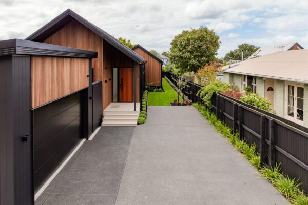 Modern home landscaping with concrete driveway and structured garden planting