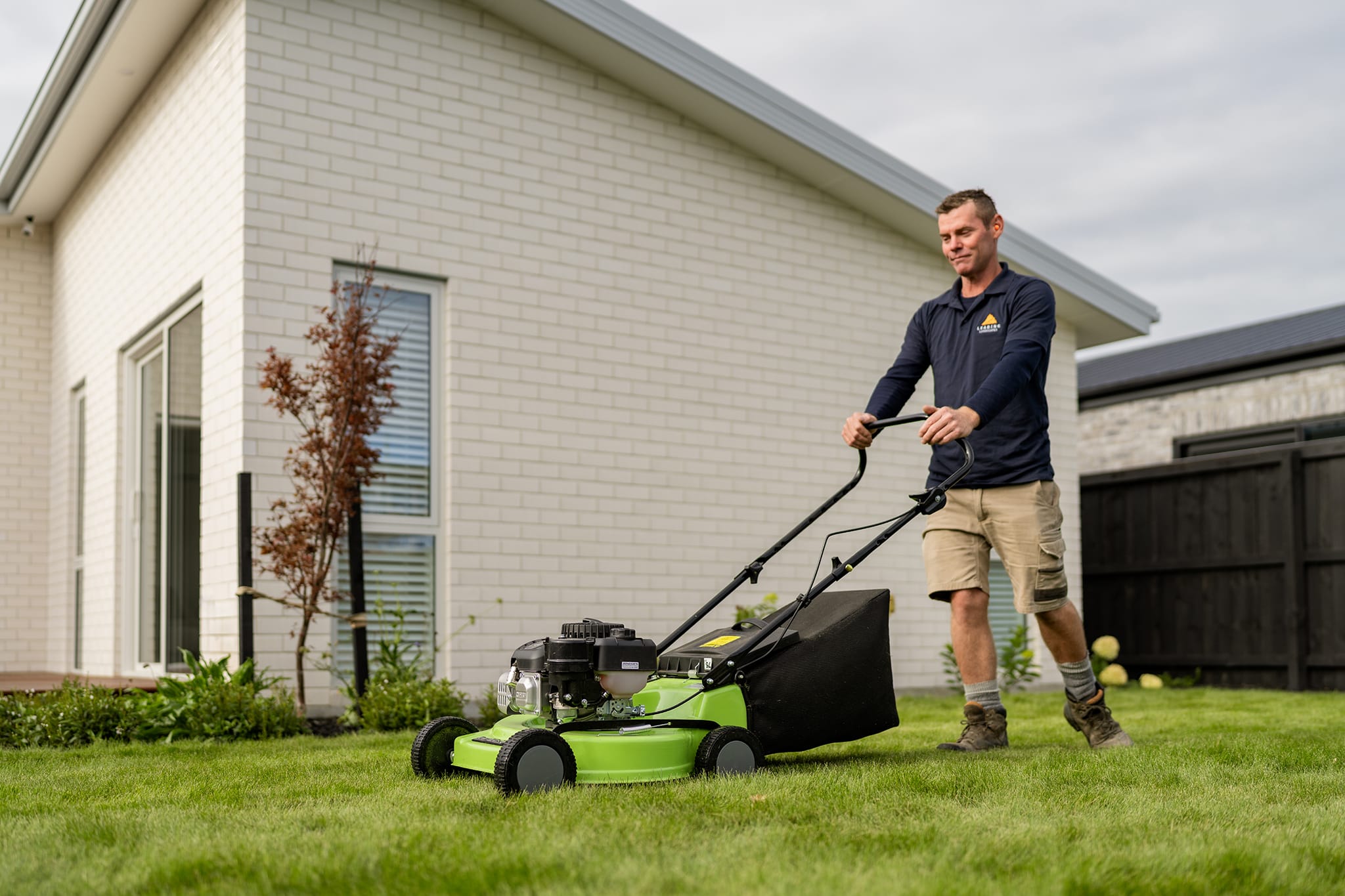 Landscaper mowing ready lawn for Leading Landscapes in Christchurch