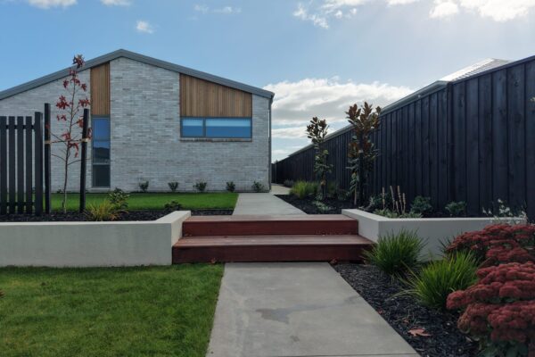 Modern new build landscaping with timber steps, concrete path, lawn and garden beds