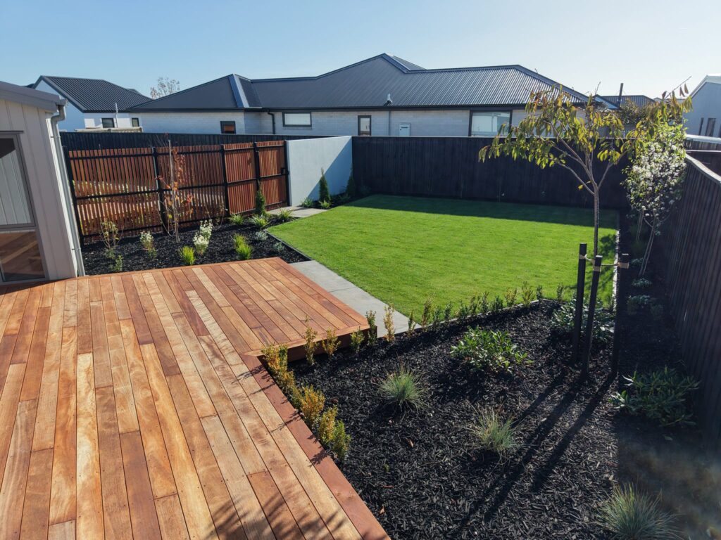 New build garden with timber deck, lawn, black mulch beds and privacy fencing
