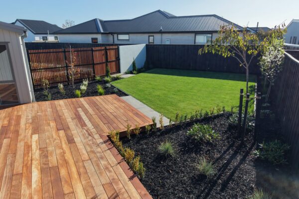 New build garden with timber deck, lawn, black mulch beds and privacy fencing