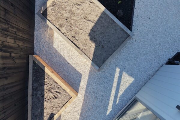 Overhead view of raised timber garden beds and white chip paths