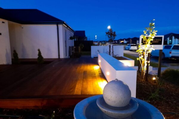 Outdoor decking, block walls and garden landscaping at night